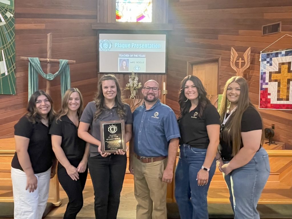 A bearded man with glasses, Mr. Stallings, stands flanked by three women to his right and two women to his left. These are the highly qualified teachers at St. Paul Elementary School.